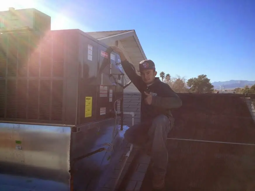 HVAC technician performing AC Tune-Up on a rooftop unit in Pigeon Forge