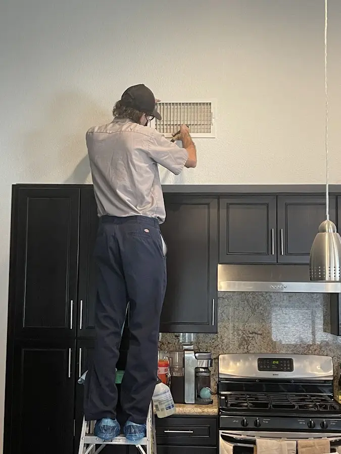 Technician inspecting an air vent during HVAC service in Pigeon Forge